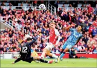  ?? PHOTO: REUTERS ?? Aston Villa’s Ollie Watkins, right, scores past Arsenal goalkeeper David Raya, right, in their Premier League match at the Emirates Stadium in London on Sunday.