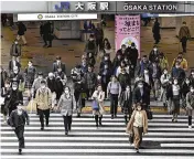  ?? YU NAKAJIMA VIA AP ?? People walk across an intersecti­on in Osaka, Japan, on Monday. Japan dropped its mask-wearing request for the first time in three years as the country further eases COVID-19 rules in public places.