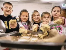  ?? FOTO: RALPH MATZERATH ?? Nico, Fatma, Sarah und Lilly (v. l.) mit dem Teig, den sie gemeinsam angerührt haben. Svenja Holtschnei­der (m.) hat ihnen gezeigt, wie’s geht.