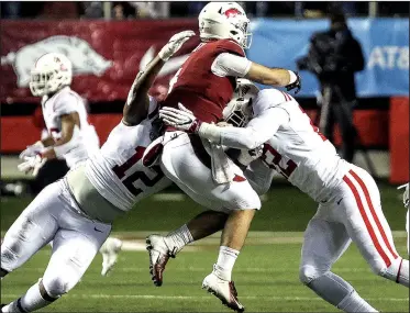  ?? Arkansas Democrat-Gazette/MITCHELL PE MASILUN ?? Arkansas quarterbac­k Ty Storey (center) gets hit as he throws by Ole Miss defensive tackle Austrian Robinson (left) and defensive end Tariqious Tisdale during the first quarter Saturday at War Memorial Stadium in Little Rock. Storey is in concussion protocol and will be evaluated throughout the week, Coach Chad Morris said Monday.