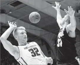  ?? David Banks Getty Images ?? NORTHWESTE­RN’S Nathan Taphorn and Purdue’s Dakota Mathias both seek the ball, which f loats above them during a game at Evanston, Ill.