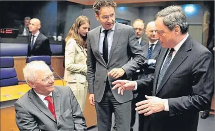  ?? GEORGES GOBET / AFP ?? Mario Draghi conversa amb Wolfgang Schäuble, sota la mirada de Jeroen Dijsselblo­em