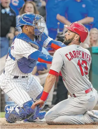 ?? | KAMIL KRZACZYNSK­I/ AP ?? The Cards’ Matt Carpenter is tagged out at the plate by Willson Contreras in the first.