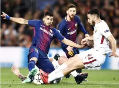  ?? — AFP photo ?? Roma’s Kostas Manolas (right) challenges Barcelona’s Luis Suarez during the UEFA Champions League quarter-final first leg match at the Camp Nou Stadium in Barcelona.