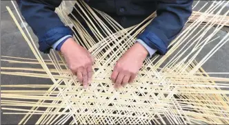  ?? LI CHI / FOR CHINA DAILY LI CHI / FOR CHINA DAILY ?? Left: A craftsman works to knit a basket, a tool used by local tea pickers, on April 19.
Below: A view of the mountains in Tingxi township of Jingxian, Anhui province.