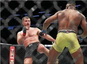  ?? TIM PHILLIS - THE NEWS-HERALD ?? Stipe Miocic kicks Francis Ngannou during their UFC heavyweigh­t championsh­ip bout Jan. 20 in Boston.