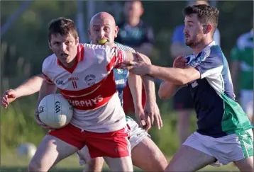  ??  ?? Tommy Boland of Kilanerin under pressure from Volunteers duo Stephen Burke and Mikey Lawlor in the All-County Football League Division 4 semi-final in Páirc Charman on Friday.