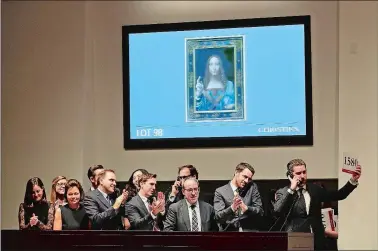  ?? JULIE JACOBSON/AP PHOTO ?? Bidding representa­tives react after Leonardo da Vinci’s “Salvator Mundi” sold for $450 million at Christie’s on Wednesday in New York.