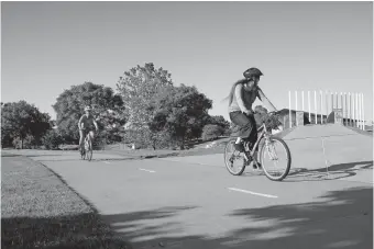  ?? OKLAHOMAN] [DOUG HOKE/ THE ?? People ride bikes along the Oklahoma River Trail near the Chesapeake Boathouse on Friday.