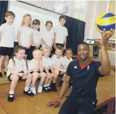  ??  ?? British Olympic volleyball player Peter Bakare is pictured with pupils six years ago.