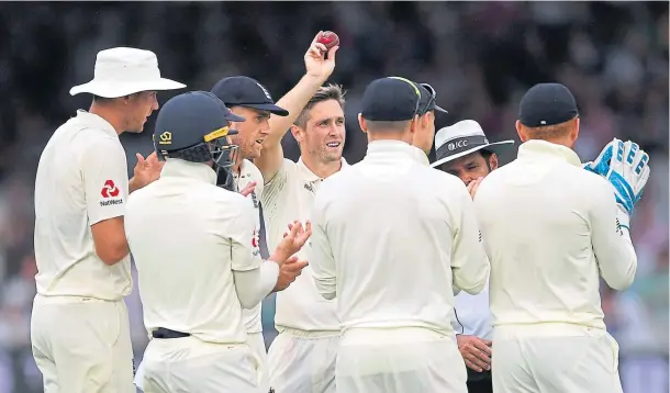  ??  ?? HIGH FIVES: England’s Chris Woakes is congratula­ted after taking his fifth wicket at Lord’s yesterday