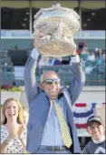  ?? Eduardo munoz Alvarez / Associated Press ?? trainer mark Casse celebrates with the trophy after Sir Winston won the Belmont Stakes last year in elmont.