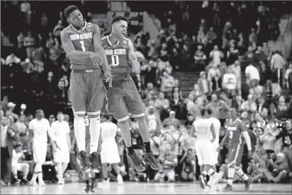  ?? STEPHEN DUNN/GETTY IMAGES ?? Jae’Sean Tate (1) and D’Angelo Russell celebrate Ohio State’s overtime victory over Virginia Commonweal­th. Russell scored 28 points.