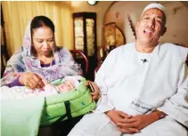  ??  ?? Sudanese businessma­n Alithi Yousef and his wife Manal Fadlallah hold their four-month-old granddaugh­ter Lojien at their home in a suburb of the capital Khartoum. (AFP)