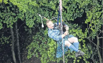  ??  ?? Roddy Garden plays his pipes as he is launched across the gorge.