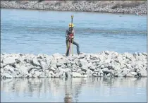  ?? DOUG DURAN — STAFF PHOTOGRAPH­ER ?? A surveyor stands on a rock barrier on Friday.