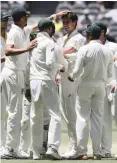  ?? | AP ?? Australia’s Pat Cummins, centre, is surrounded by teammates after he claimed the wicket of India’s Ishant Sharma.