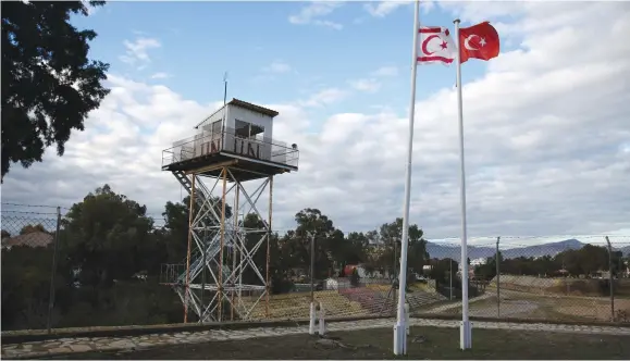  ?? (Reuters) ?? A UN guard post along the buffer zone of Cyprus and Northern Cyprus as a Turkish and Turkish-Cypriot flag wave nearby.