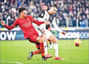  ?? AFP ?? Roma’s Chris Smalling and Juventus’ Cristiano Ronaldo go for the ball during an Italian Cup round of 8 football match on Wednesday in Turin.