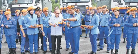  ??  ?? Uggah (centre) and Azmy cut the ribbon at the handover ceremony.