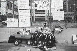  ?? Stephen Maturen / Getty Images ?? Teacher and activist Kaia Hirt sits chained to the fencing outside the Hennepin County Government Center on Tuesday. She wants to bring attention to killings by police in Minnesota.