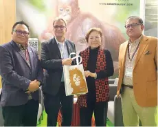 ?? ?? Liew (second right) presenting a Sabah orangutan promotiona­l bag to Steinmetz, witnessed by Bangkuai (right) and Julinus (left), at the STB booth.