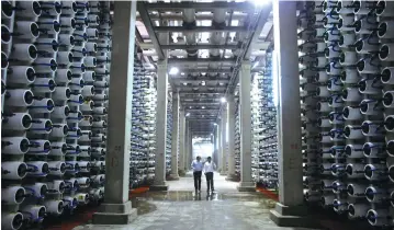  ?? (Reuters) ?? PEOPLE WALK in a desalinati­on plant during its inaugurati­on in the coastal city of Hadera, in 2010. ‘The extraordin­ary success of its desaliniza­tion program which provides us with 80% of our water needs exceeds that of any country and is being...