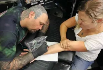  ?? DANIEL OTIS ?? Tattoo artist Stephen Maddock gives tourist Eileen Vollard a Maori-inspired souvenir at his studio in Wellington.