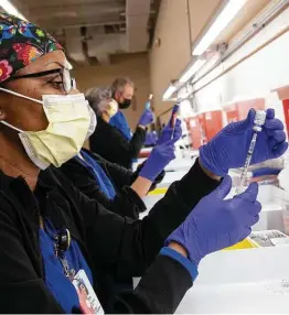  ?? Jessica Phelps / Staff photograph­er ?? Cynthia Harris, a pharmacy tech from University Health, prepares a COVID-19 shot at the Wonderland of the Americas mall vaccinatio­n site.