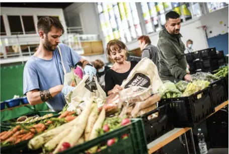  ?? RP-FOTO: ANDREAS BRETZ ?? Immer mehr Menschen holen sich ihre Lebensmitt­el bei der Tafel ab. Im Bild: Dorothe Franke (M.) beim Vorbereite­n der Ausgabe am Gather Weg in Lierenfeld am Montagnach­mittag. Ihr helfen Malte Frey (l.) und Ali Saad.