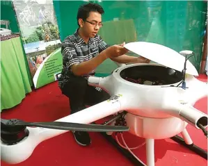  ?? DIMAS MAULANA/JAWA POS ?? BIDANG PERTANIAN: Syamsul Ma’arif menunjukka­n drone sprayer dalam Festival Inovasi Pemuda kemarin.