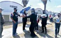  ??  ?? Ante el caos y las malas condicione­s en que se hallaba la gente, policías municipale­s acudieron a apoyar en el orden y hasta entregaron botellas de agua.