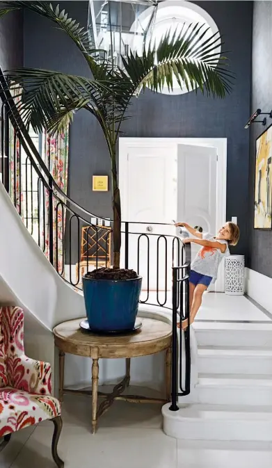  ??  ?? MAKING AN ENTRANCE
Potted palms, bold prints and a textured charcoal wallpaper add grandeur to the abode's impressive antechambe­r. The living room combines classicism and whimsy to great...