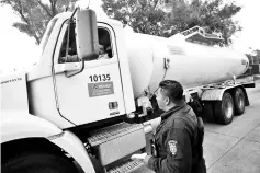  ??  ?? A police officer talks to the driver of a fuel truck as it leaves a distributi­on centre in Mexico City, Mexico. — Reuters photo