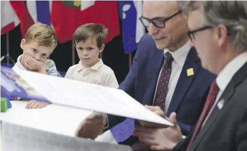  ?? SEAN KILPATRICK / THE CANADIAN PRESS ?? Bryson and Austin Boyce-Pettes watched Monday as federal Social Developmen­t Minister Jean-Yves Duclos, second from right, and provincial ministers of education including P.E.I.’s Doug Currie signed a new child-care deal into law.