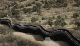  ?? AP FILE ?? ‘PLAIN AND SIMPLE’: A Customs and Border Control agent patrolling on the US side of a razor-wire-covered border wall along the Mexico east of Nogales, Ariz. A North Dakota constructi­on company favored by President Donald Trump has received the largest contract to build a wall along the U.S.Mexico border.