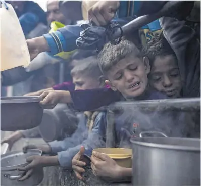  ?? Fatima Shbai / AP ?? Unos niños palestinos hacen cola para conseguir comida, el pasado viernes en Rafah.