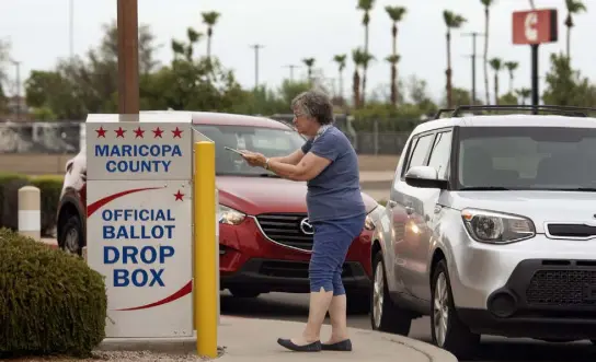  ?? Rebecca Noble, © The New York Times Co. ?? A voter drops off a ballot during Arizona’s primary election Aug. 2 in Mesa. A nascent effort to surveil drop boxes for potential fraud is taking shape in at least 10 states, worrying election officials and law enforcemen­t.