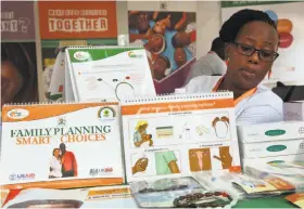  ?? Stephen Wandera / Associated Press ?? Health worker Sylvia Marettah Katende displays reproducti­ve health products and informatio­n Sept. 26 at a family planning exhibition in Kampala, Uganda.