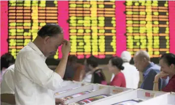  ?? — Reuters ?? Investors look at computer screens showing stock informatio­n at a brokerage house in Shanghai, China.