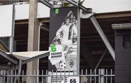  ??  ?? Supporters in en rond Borussia Park, het stadion van de club dat in 2004 werd opgeleverd. Onder: een plakkaat in het stadion met daarop Rainer
Bonhof, een speler van het team van Gladbach in de jaren 70.