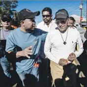  ?? Alejandro Gutiérrez Mora Picture Alliance ?? FATHER Alejandro Solalinde, right, visits Central American immigrants at a shelter in Tijuana in 2018.