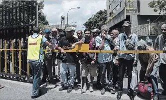  ?? CARLOS BECERRA
BLOOMBERG ?? People wait for free soup in Caracas on Saturday as shops closed out of confusion caused by economic reform.