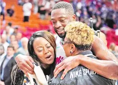  ??  ?? Miami Heat guard Dwyane Wade hugs his sister Tragil Wade (left) and mother Jolinda Wade after defeating the Philadelph­ia 76ers at American Airlines Arena, in this Feb 27 file photo. — USA TODAY Sports photo