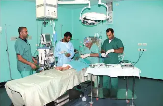  ??  ?? Medics operating on a Palestinia­n child at the Kuwaiti Hospital in Gaza.