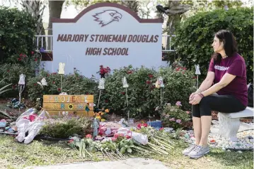  ?? MATIAS J. OCNER mocner@miamiheral­d.com ?? Julie McNichol visits a makeshift memorial outside of Marjory Stoneman Douglas High School in Parkland on Feb. 14 to mark two years since the shooting that killed 17 students and staffers and wounded 17 other people.