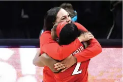  ?? AP Photo/Morry Gash ?? ■ Arizona head coach Adia Barnes gets a hug from guard Aari McDonald (2) at the end of a women’s Final Four NCAA college basketball tournament semifinal game against Connecticu­t on Friday at the Alamodome in San Antonio. Arizona won, 69-59.