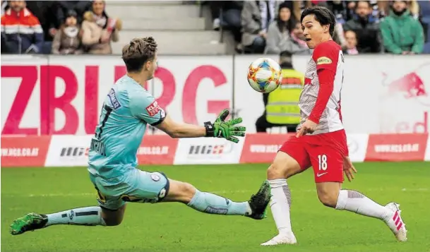  ?? BILD: SN/APA/KRUGFOTO ?? Salzburgs Takumi Minamino hatte mit einem Heber über Sturm-Torhüter Jörg Siebenhand­l Pech: Der Ball sprang von der Stange zurück.