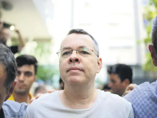  ??  ?? Pastor Andrew Craig Brunson is escorted by plaincloth­es police officers as he arrives at his house in Izmir, July 25.