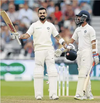  ?? / PHILIP BROWN/GETTY IMAGES ?? Virat Kohli celebrates reaching his century alongside teammate Ajinkya Rahane against England at Trent Bridge in Nottingham yesterday.